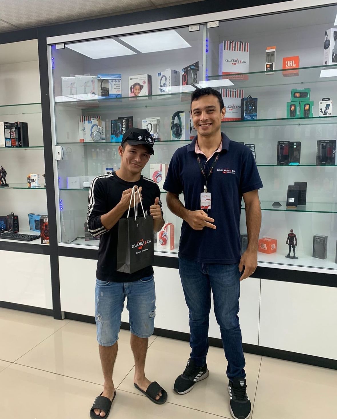 Cliente satisfeito com seu novo smartphone ao lado de nosso atendente